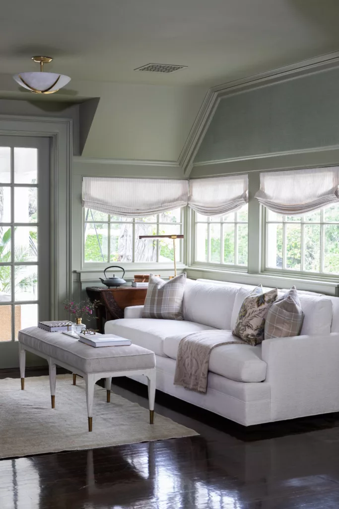 primary bedroom sitting area soft serene sofa roman shades green bedroom
