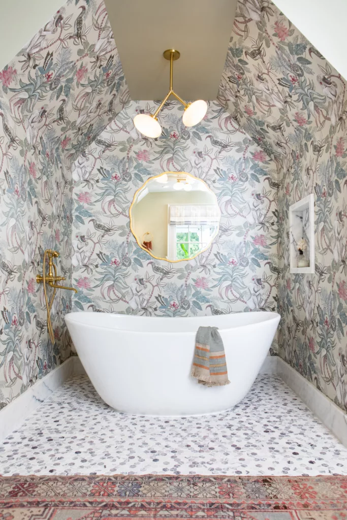 primary suite bathroom tub alcove soacking tub jungle wallpaper african lilac brass tub filler mosaic tile floor serene adventurous design 