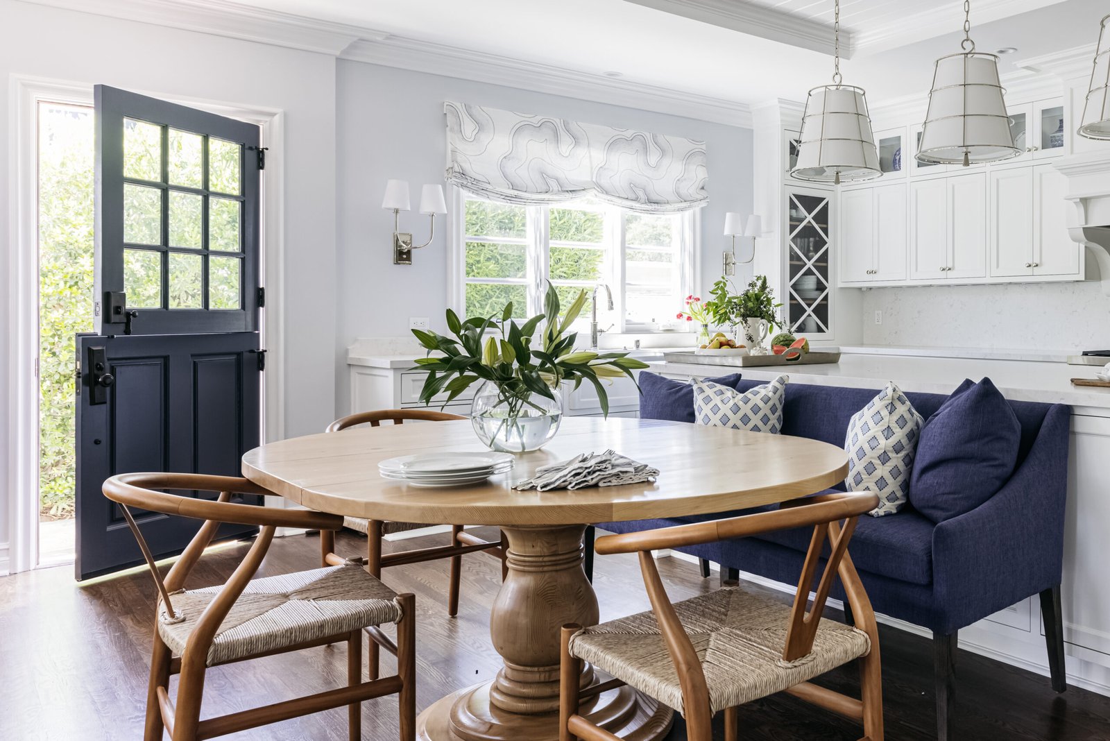 Historic preservation - kitchen designed by Coco Maison with custom banquette and island, and a wood dining table.